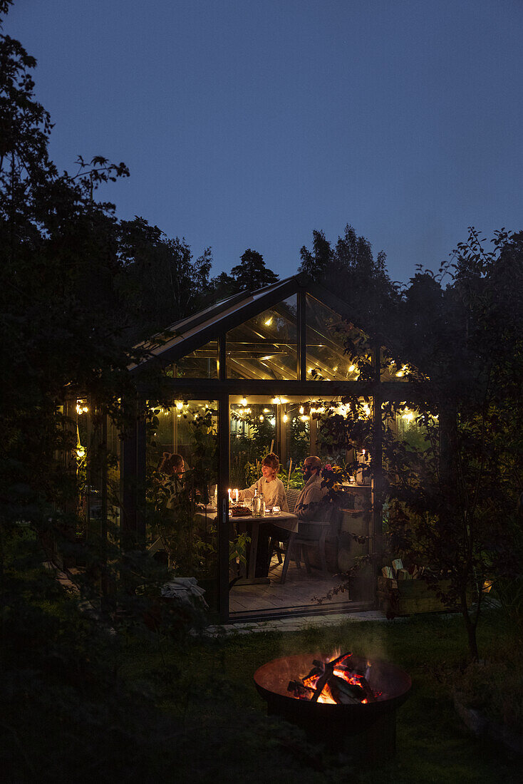 Illuminated greenhouse in garden
