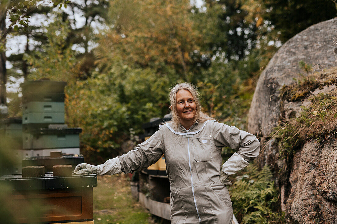 Imker in der Nähe des Bienenstocks stehend