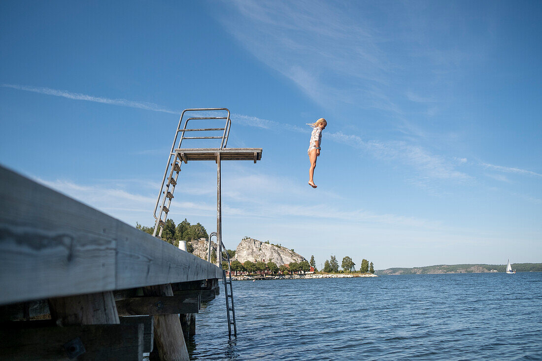 Mädchen springt vom Sprungturm