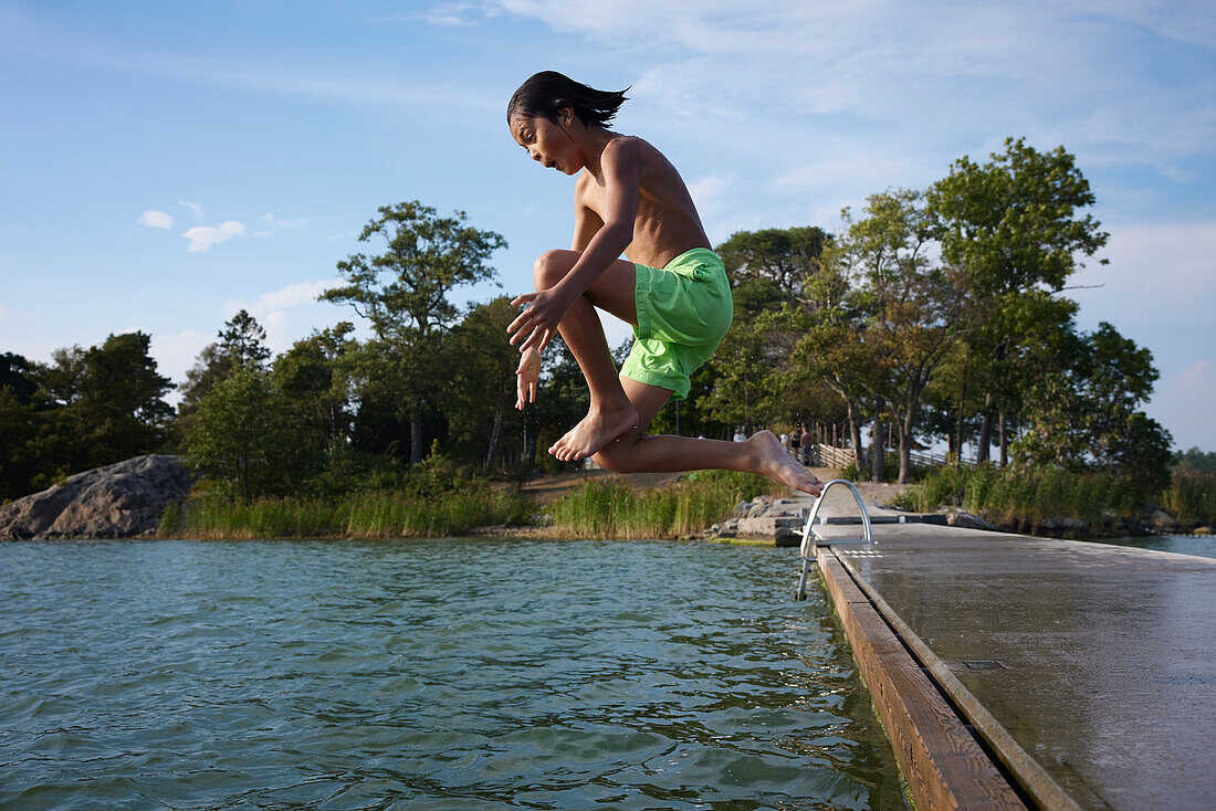 Junge, der ins Wasser springt