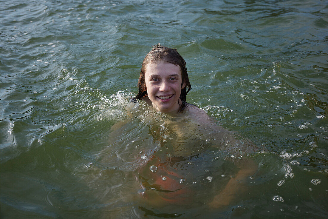 Teenage boy swimming in water