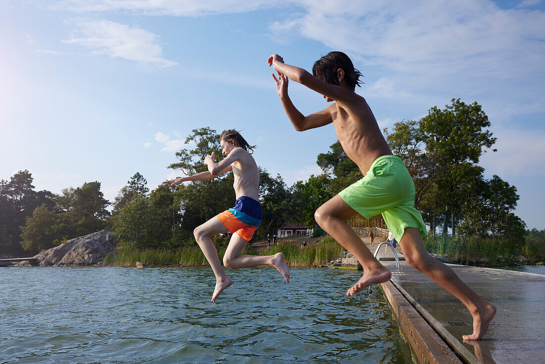 Boys jumping into water