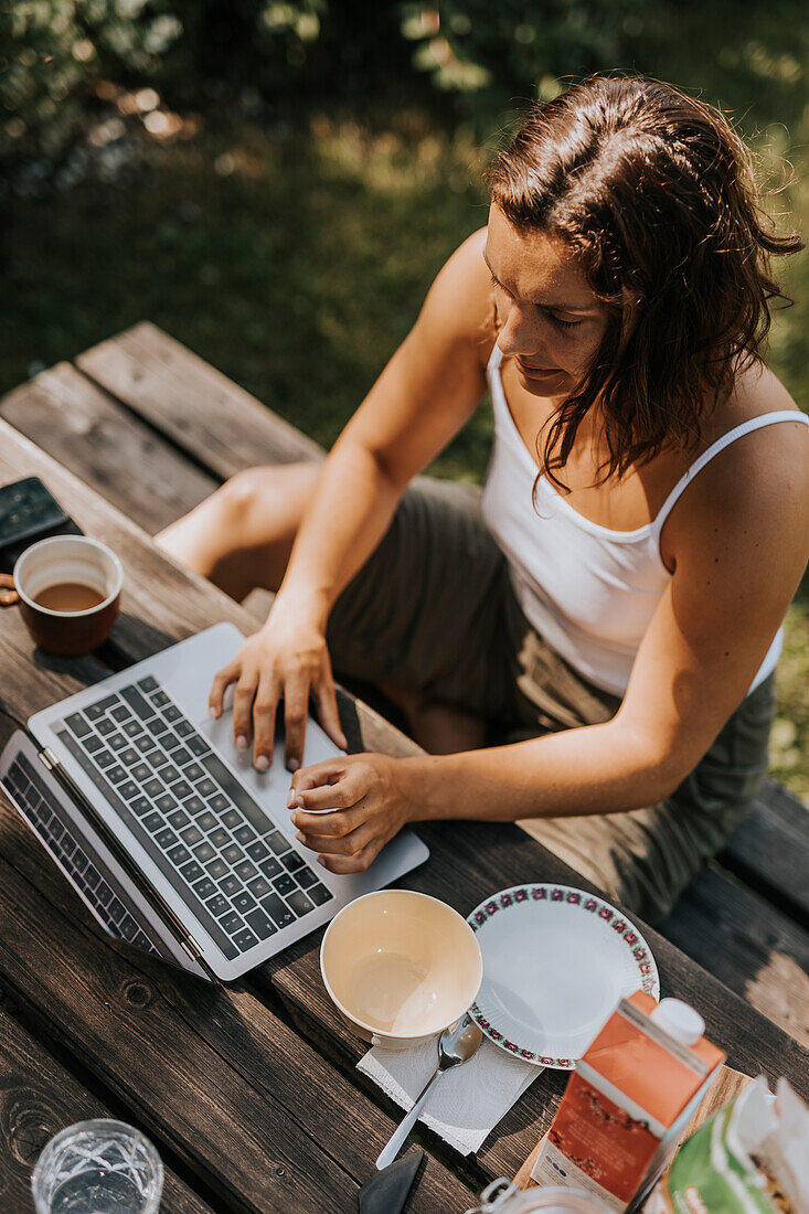 Hochformatige Ansicht einer Frau, die einen Laptop benutzt