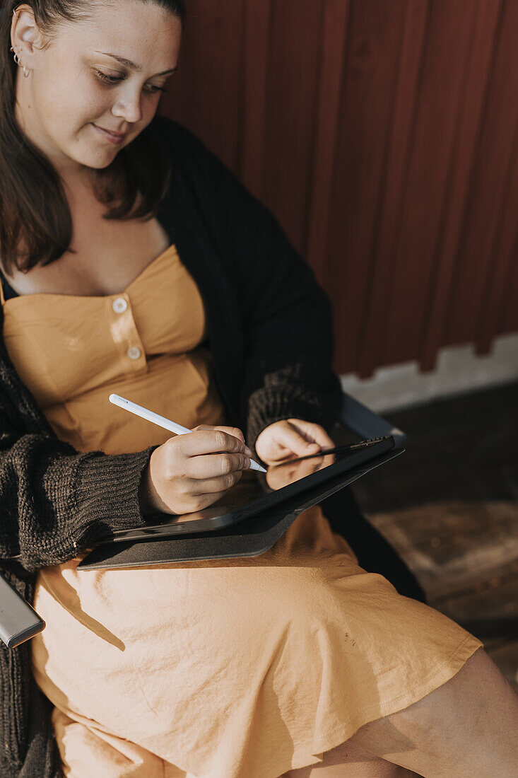 Smiling woman using digital tablet