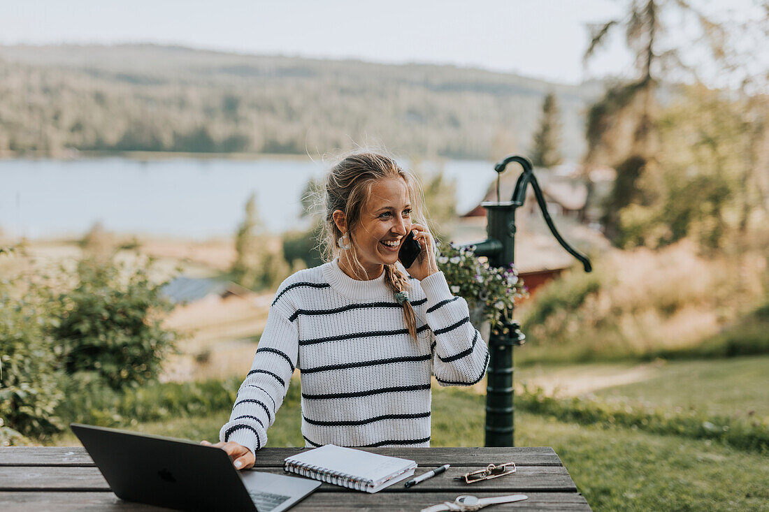 Junge Frau, die mit dem Handy fotografiert