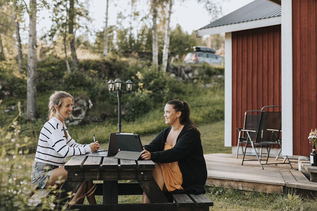 Female friends sitting on picnic bench