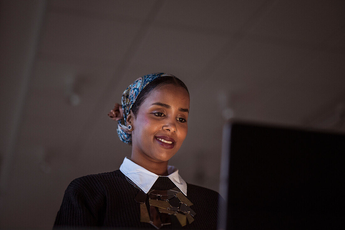 Smiling young woman working on laptop