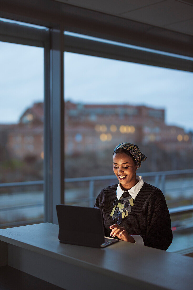 Smiling young woman working on laptop