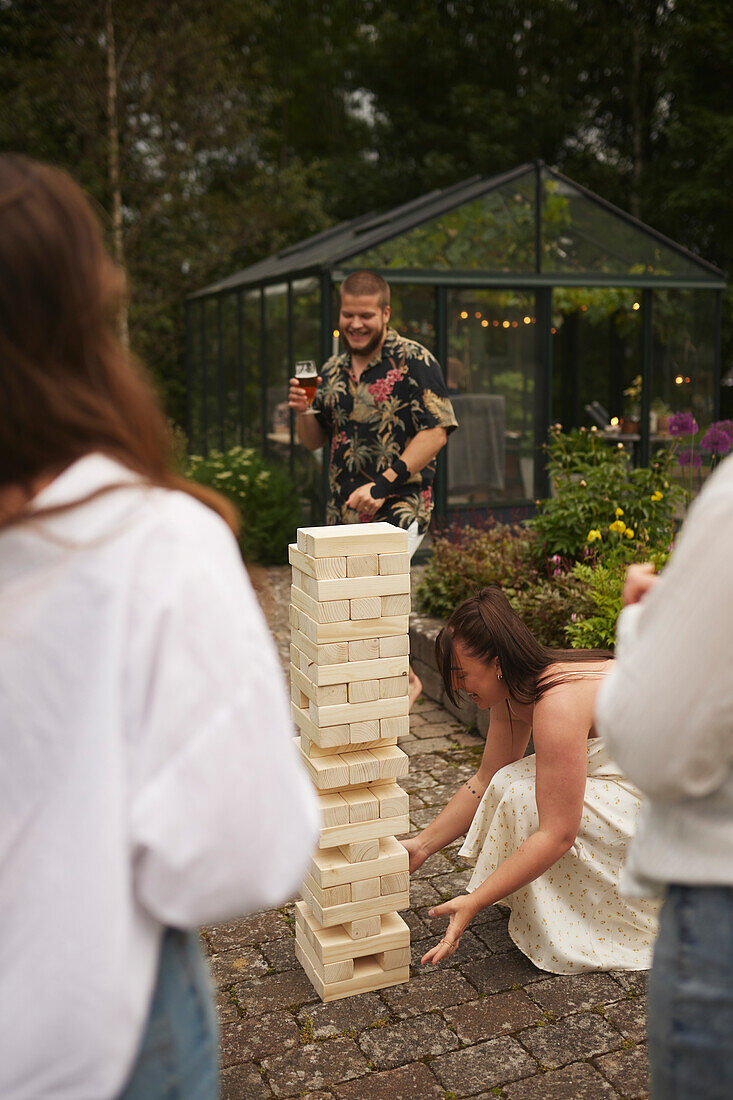 Freunde spielen Riesen-Jenga im Garten