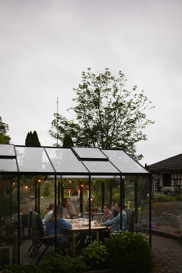 Friends having meal in greenhouse