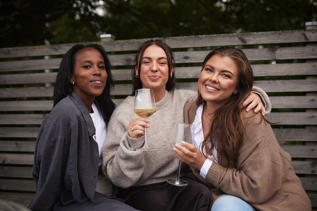 Smiling female friends looking at camera