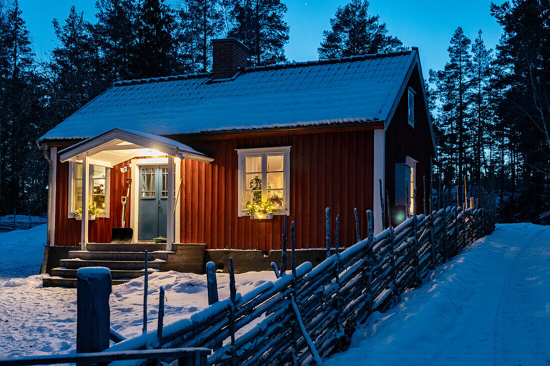 Außenansicht eines verschneiten roten Hauses in Falun