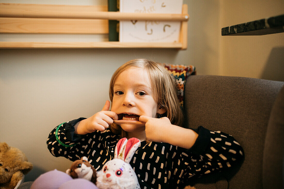 Portrait of girl making face at home