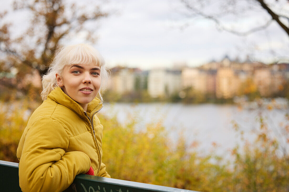 Lächelnde Frau auf einer Bank sitzend