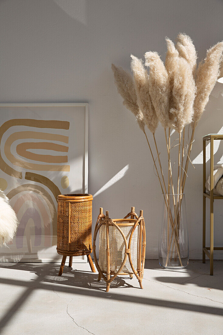 Dried plants in vase behind floor lamps