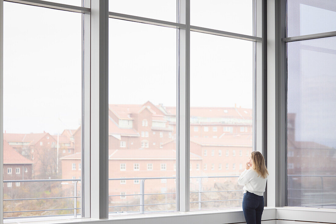 Woman looking through window