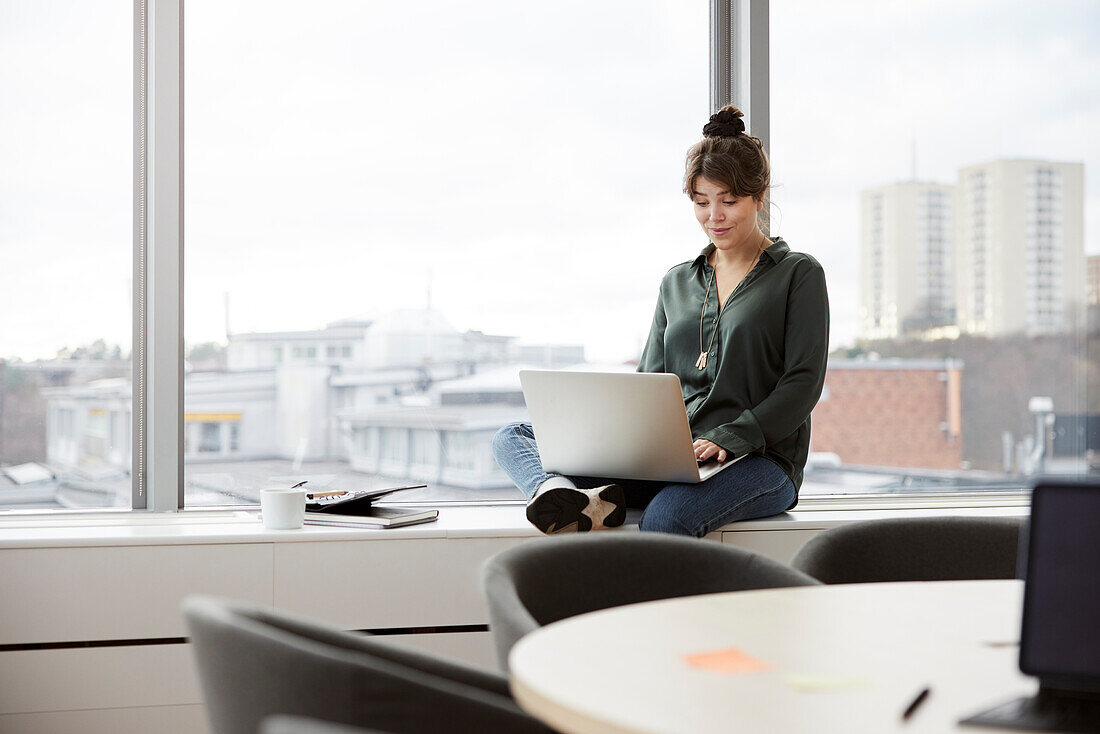 Businesswoman using laptop in office