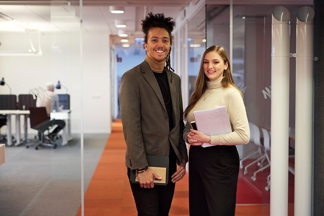 Portrait of business people standing in office corridor