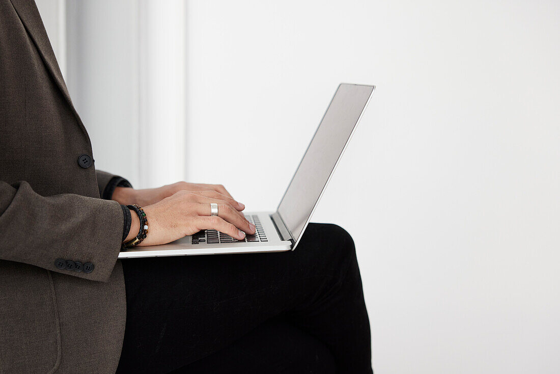 Geschäftsmann tippt auf einem Laptop im Büro