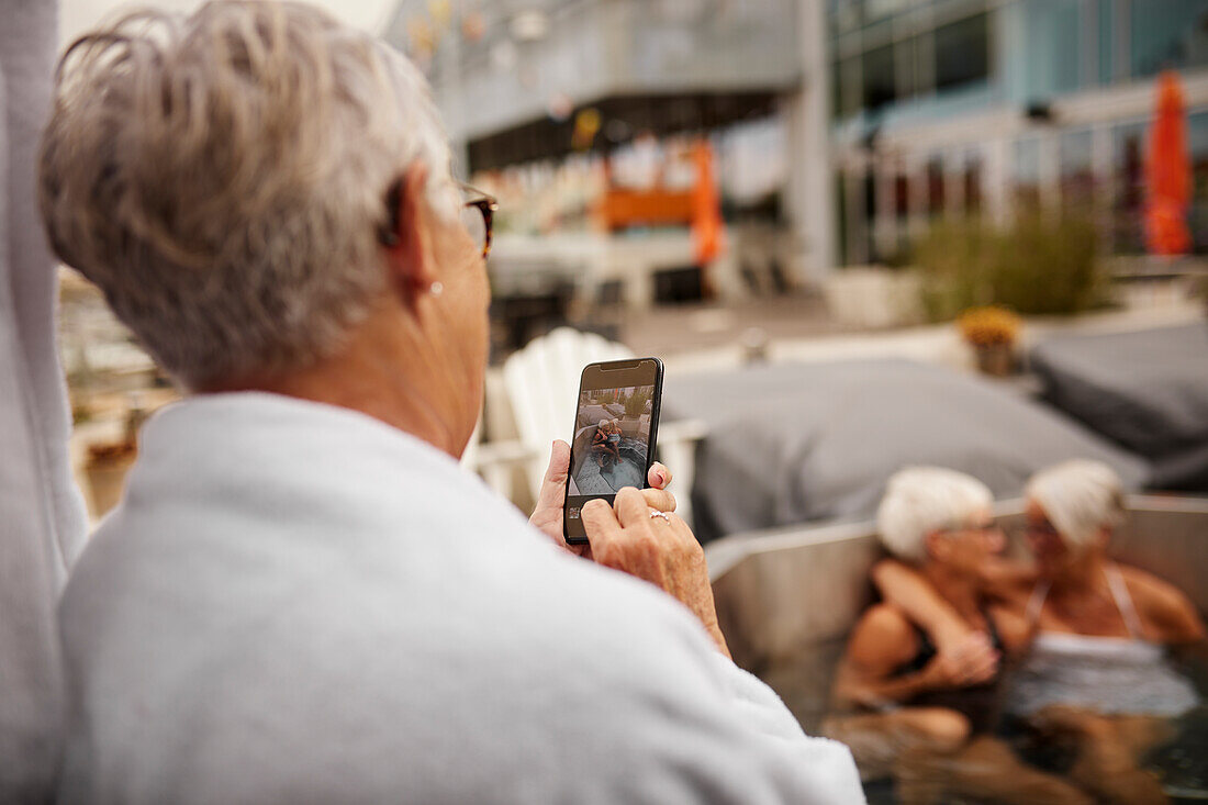 Ältere Frau beim Fotografieren mit dem Handy