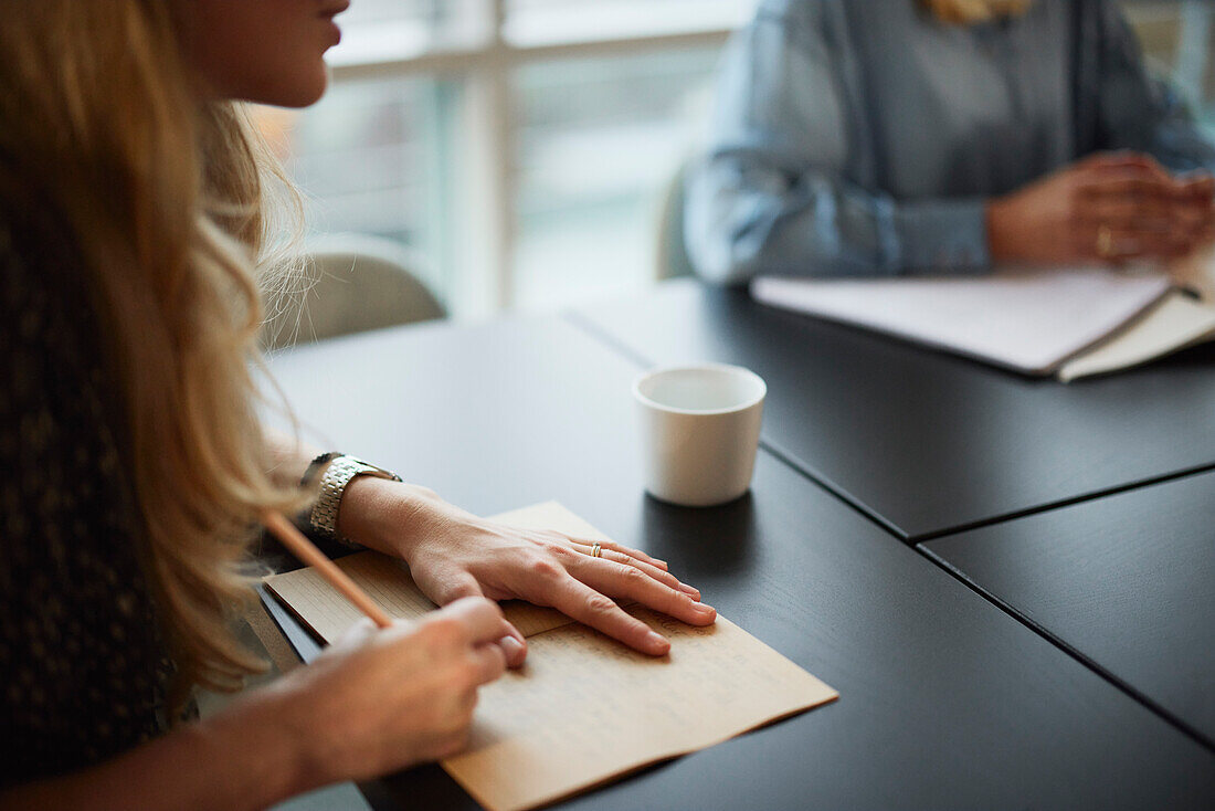 Frau macht Notizen während einer Besprechung