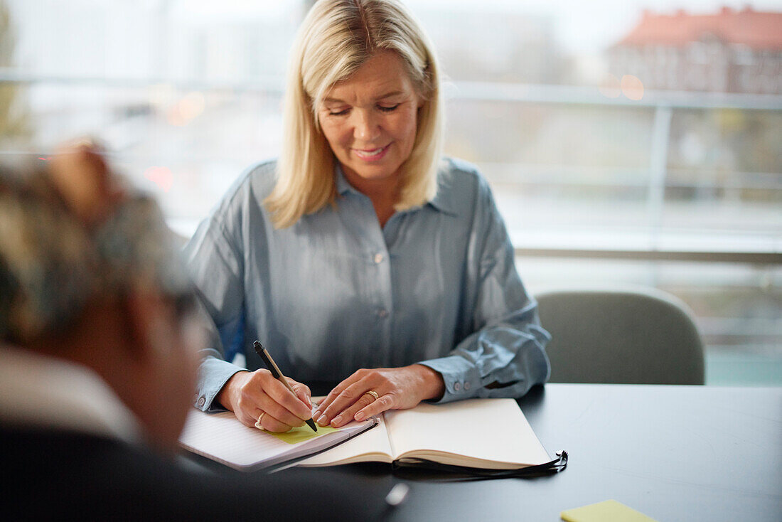 Woman taking notes during meeting