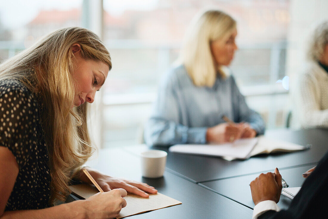 Woman taking notes during meeting