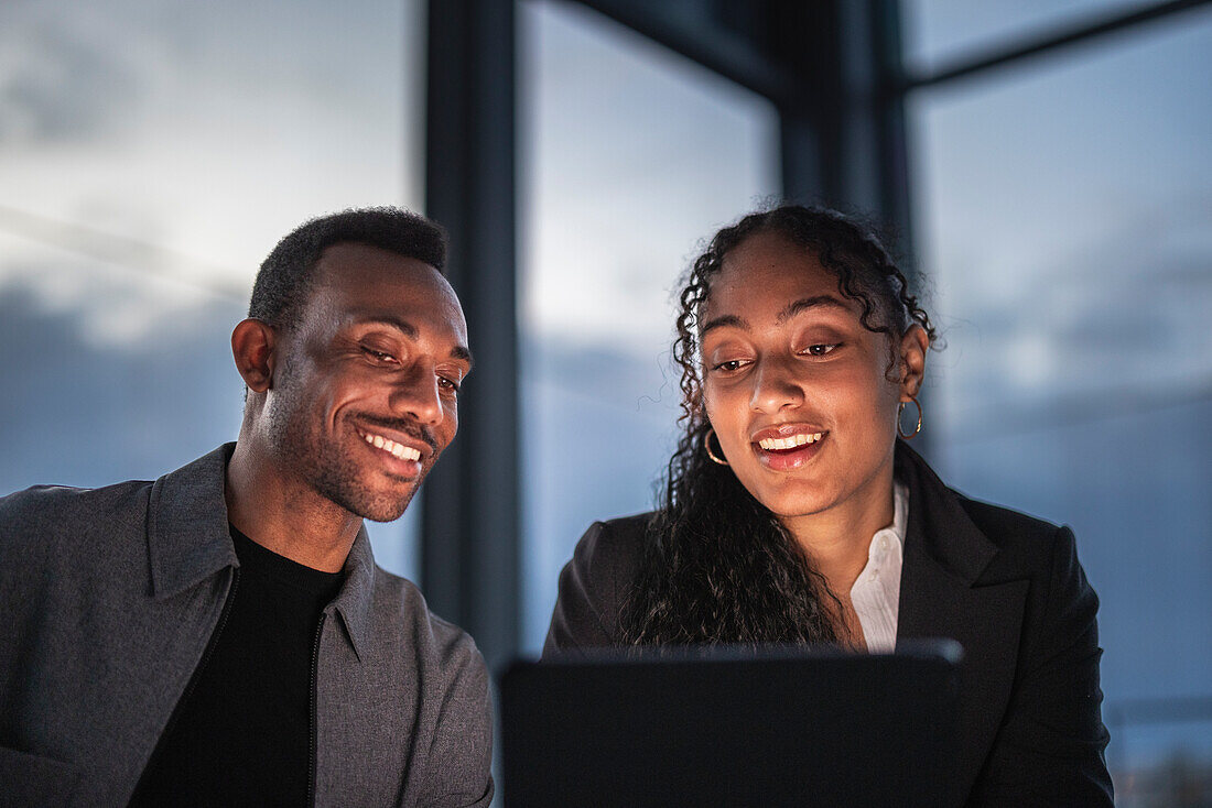 Smiling business people working late