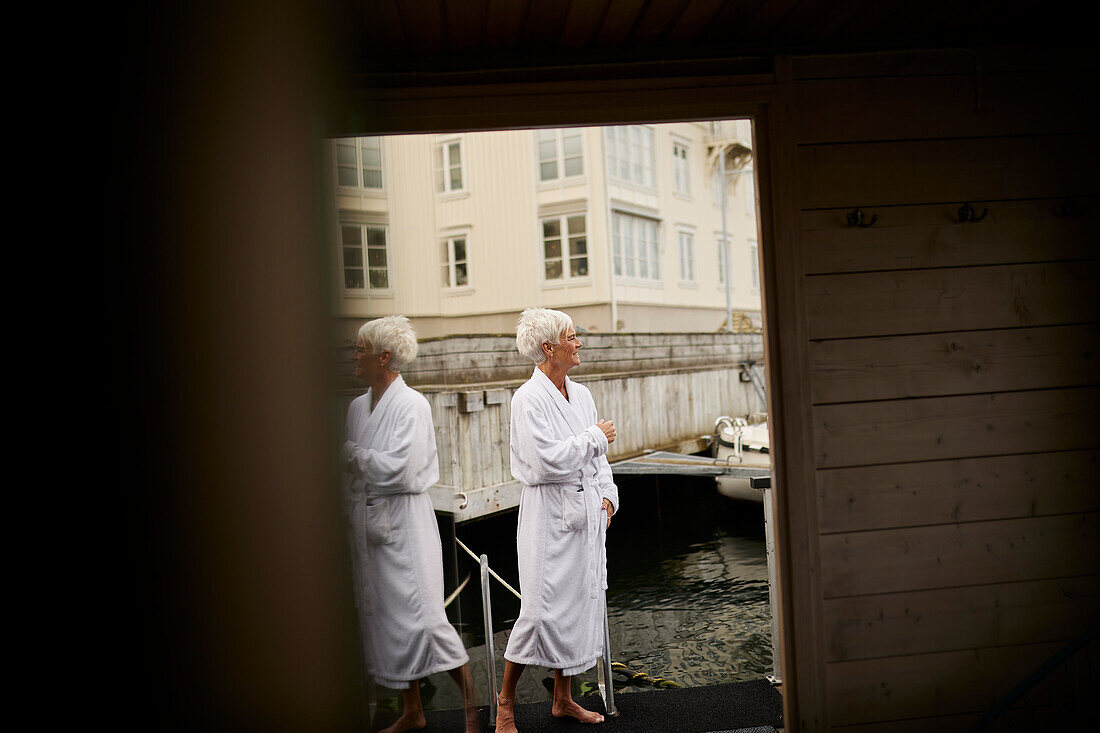 Senior woman wearing dressing gown at sea