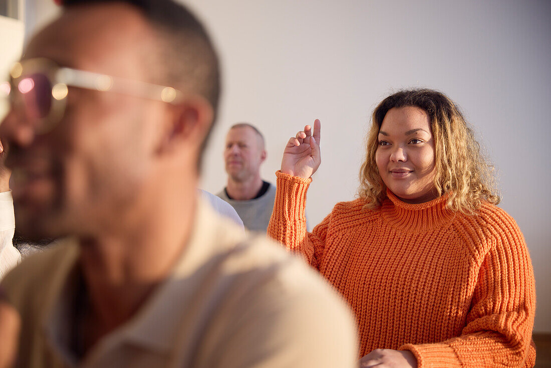 Frau hebt während des Workshops die Hand