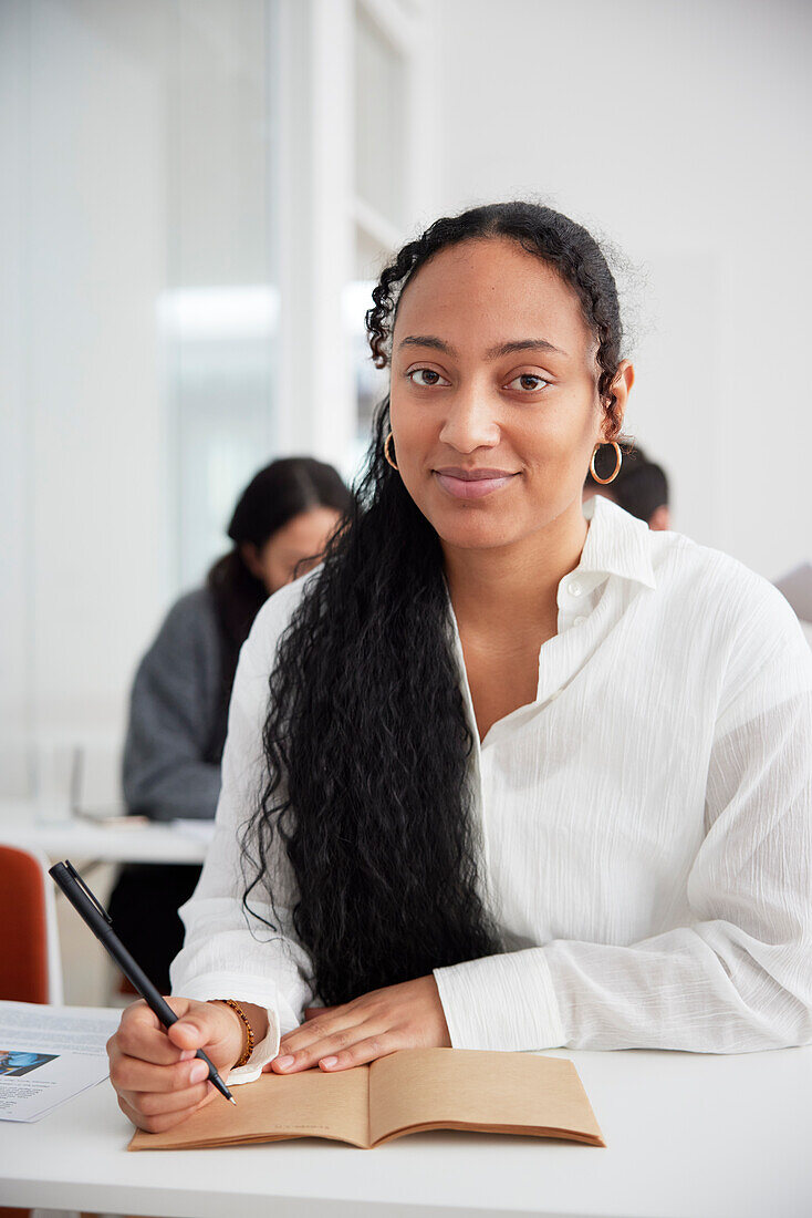 Smiling woman taking notes during workshop