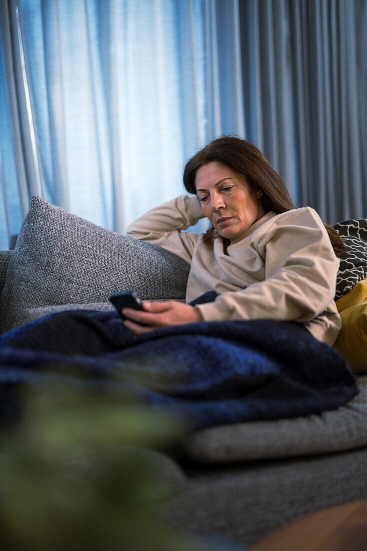 Ill woman sitting on sofa