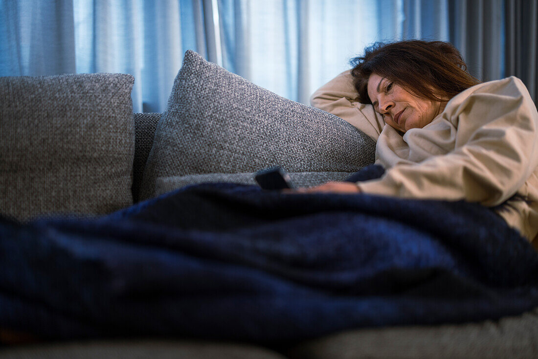 Ill woman sitting on sofa