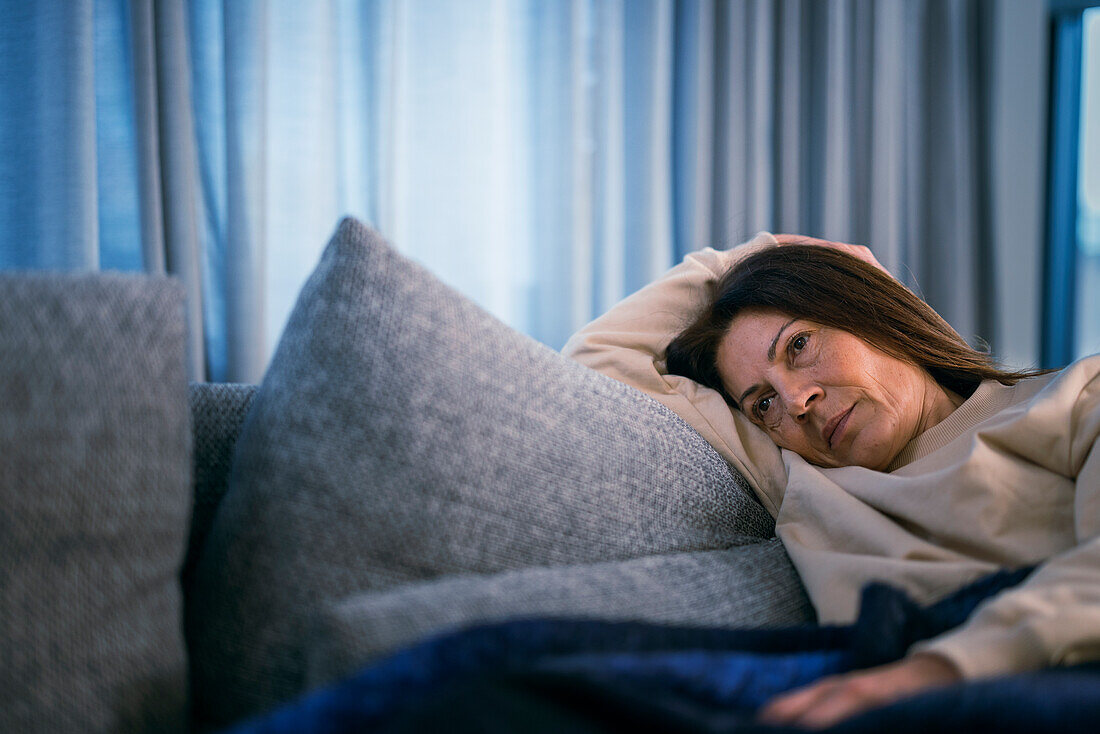 Kranke Frau auf dem Sofa liegend