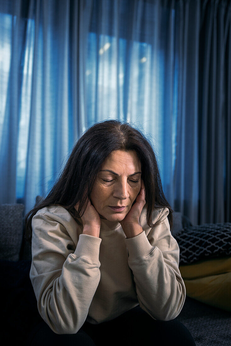 Depressed woman sitting in living room