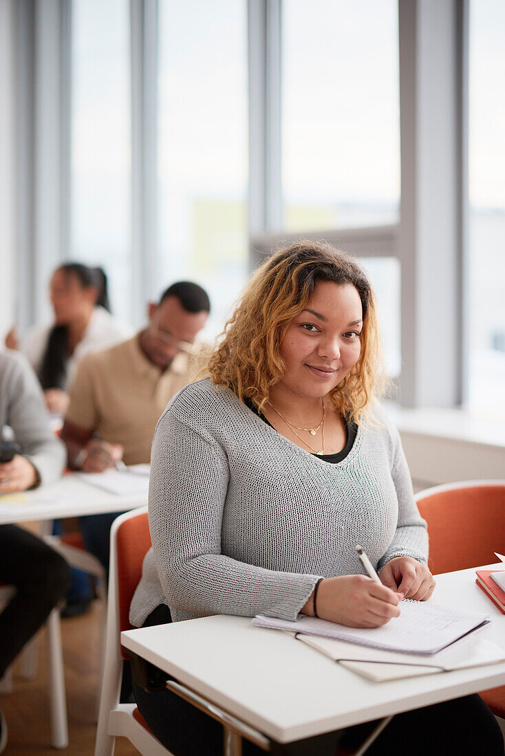 Portrait of woman making notes in class