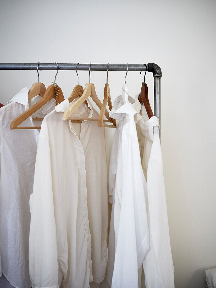 Weiße Hemden hängen auf dem Kleiderständer