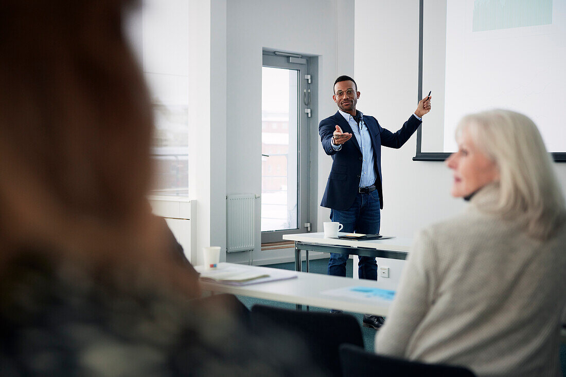 Geschäftsmann präsentiert vor Kollegen während eines Meetings