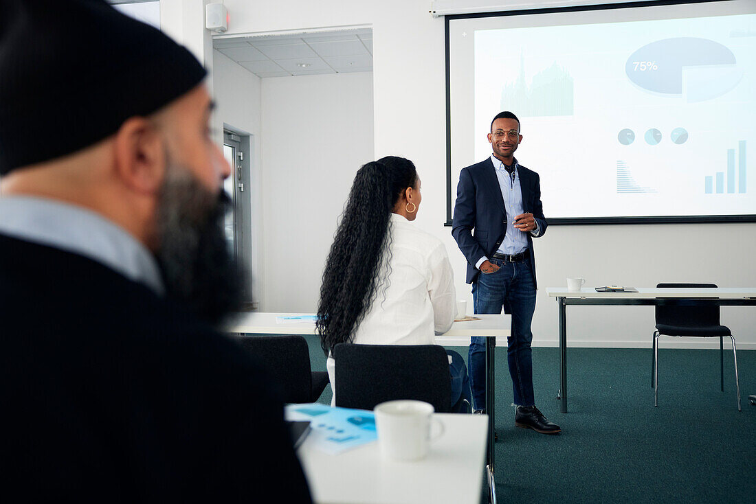 Geschäftsmann präsentiert vor Kollegen während eines Meetings