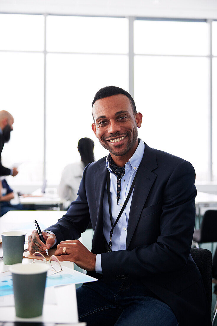 Portrait of smiling businessman sitting at desk