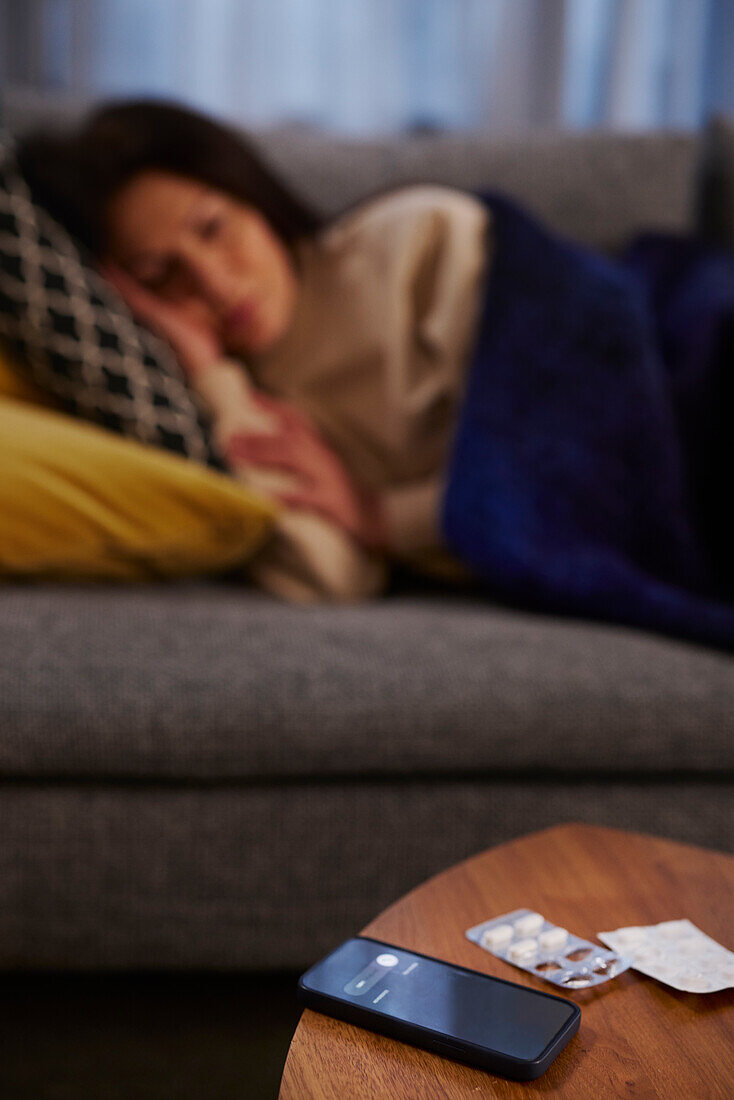 Cell phone and pills on coffee table