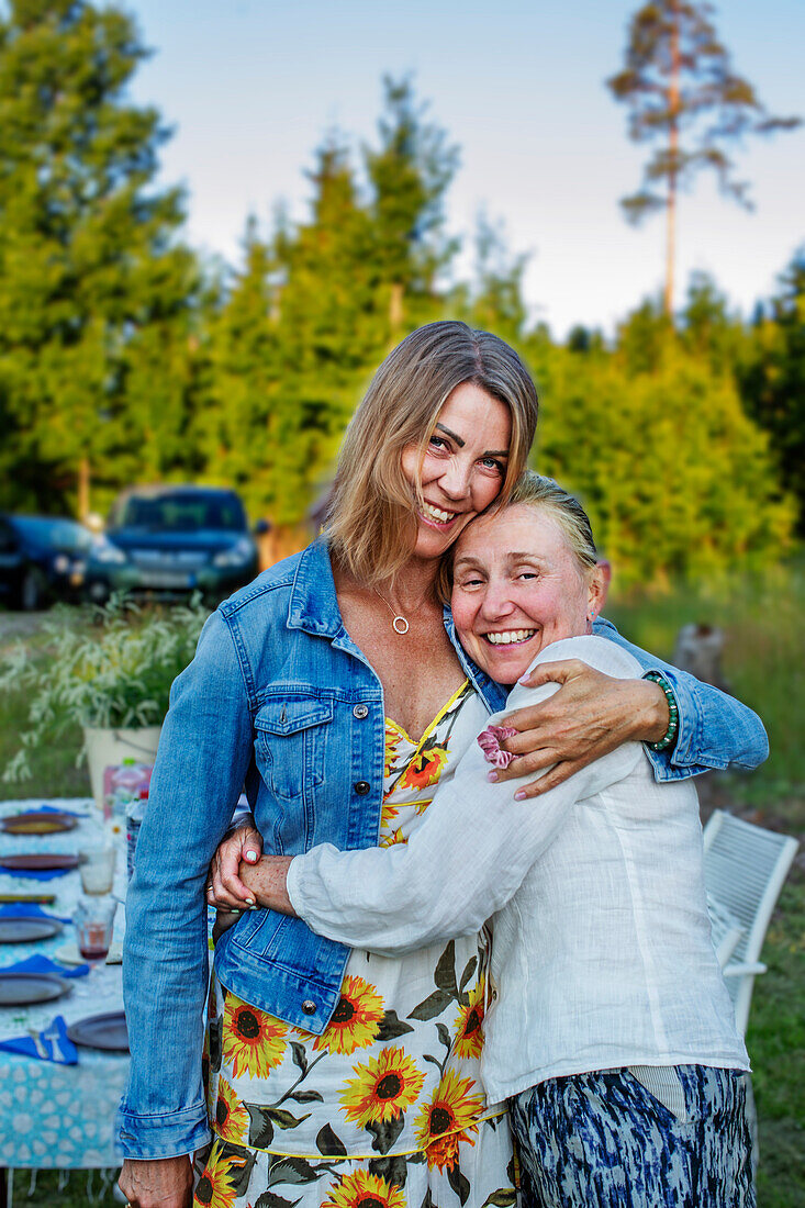 Mother and daughter hugging in garden