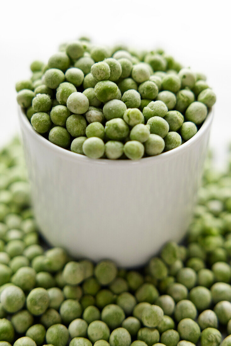 Green peas in bowl and on table