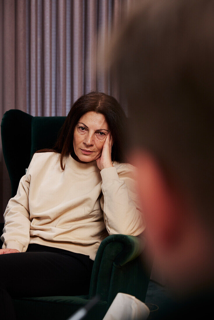 Female patient sitting in armchair at therapy session