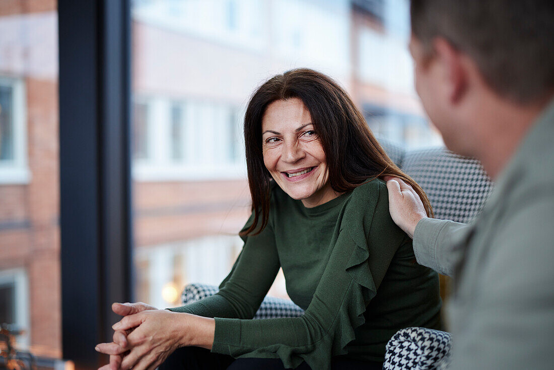 Man touching smiling woman's shoulder