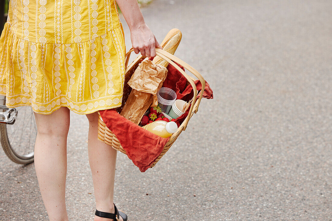 Mid section of woman carrying food in basket