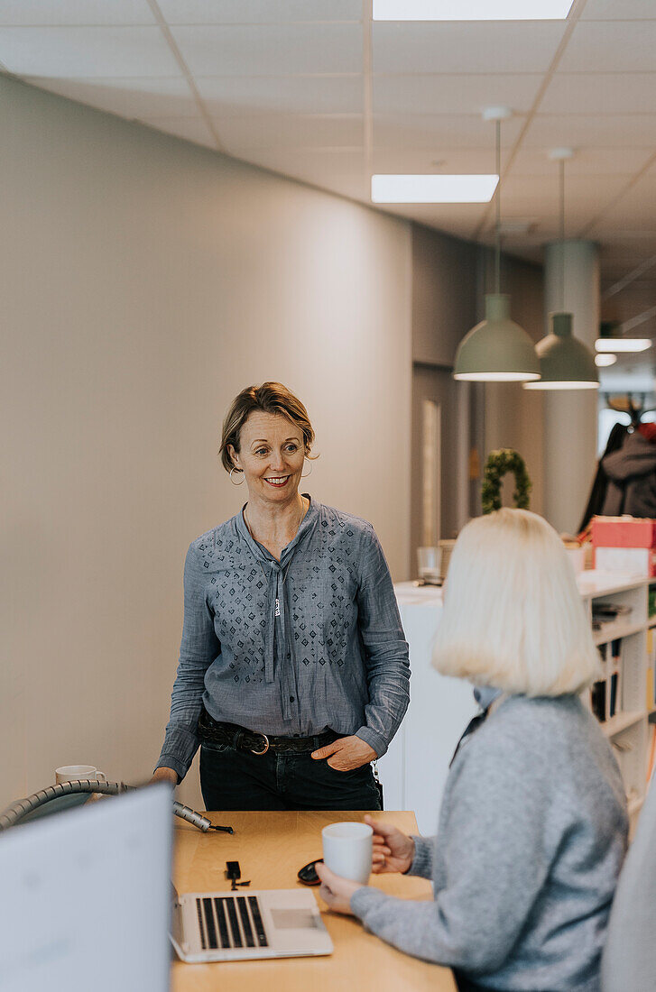 Lächelnde Frau spricht im Büro