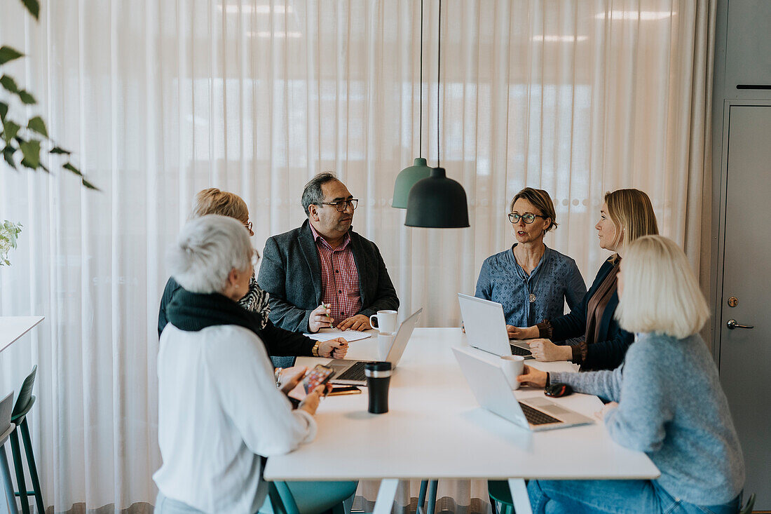 Smiling people talking in office