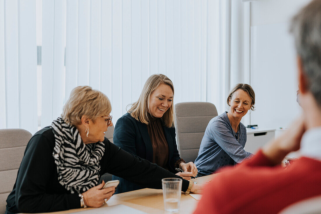 Smiling women talking during business meeting