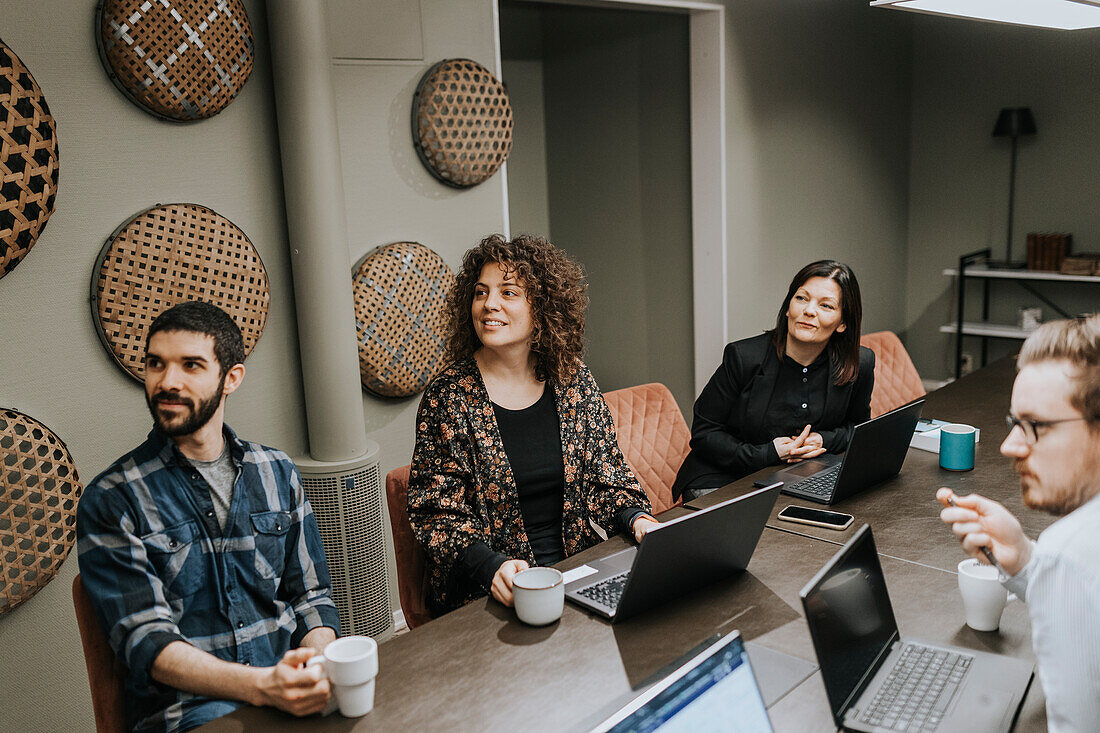 Smiling people sitting during business meeting